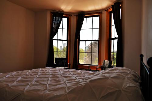 a bedroom with a bed and two large windows at Gorge View in Niagara Falls