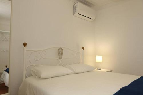 a white bed with white sheets and pillows at Casa da Catraia by Lisbon Village Apartments in Torrozelo
