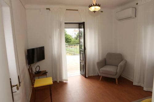 a living room with a chair and a television at Casa da Catraia by Lisbon Village Apartments in Torrozelo