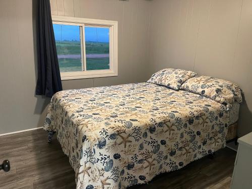a bedroom with a bed and a window at Cottages On PEI-Oceanfront in Bedeque