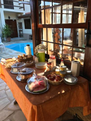 un tavolo con cibo e pane sopra di esso di Pousada Mercador a Parati