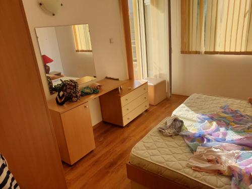 a bedroom with a bed and a dresser and a mirror at Golden Dreams in Sunny Beach