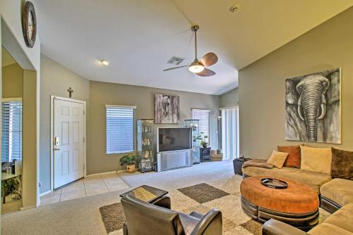 a living room with a couch and a tv at Charming Anthem Home with Fire Pit, 1 Mi to Park! in Anthem