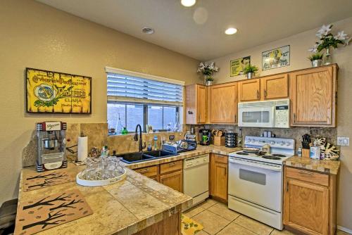 a kitchen with wooden cabinets and a white stove top oven at Charming Anthem Home with Fire Pit, 1 Mi to Park! in Anthem