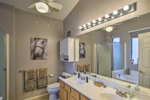a bathroom with a sink and a toilet and a mirror at Charming Anthem Home with Fire Pit, 1 Mi to Park! in Anthem