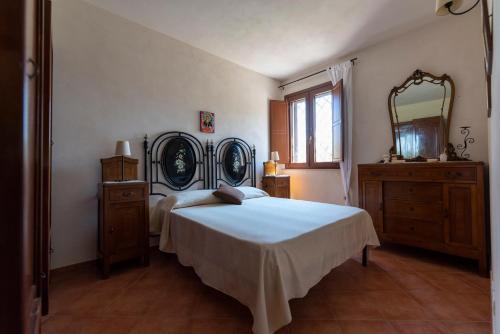 ein Schlafzimmer mit einem Bett und einem großen Spiegel in der Unterkunft Country House il Gelso e l’Ulivo in Noto