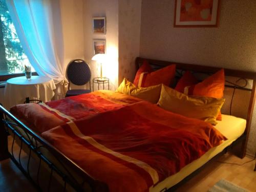 a bedroom with a large bed with an orange blanket at Haus Bergrose in Busenborn