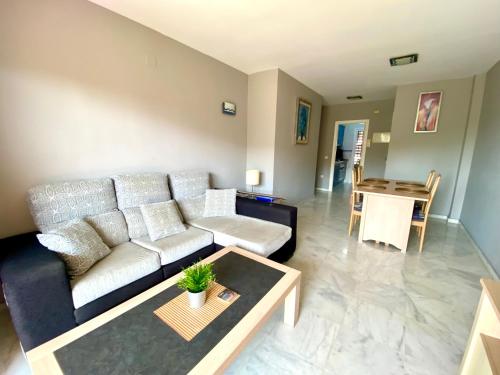 een woonkamer met een bank en een tafel bij Riviera Golf apartment in Mijas Costa