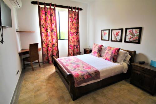 a bedroom with a bed and a desk and a window at Amazilia Hotel in Pereira