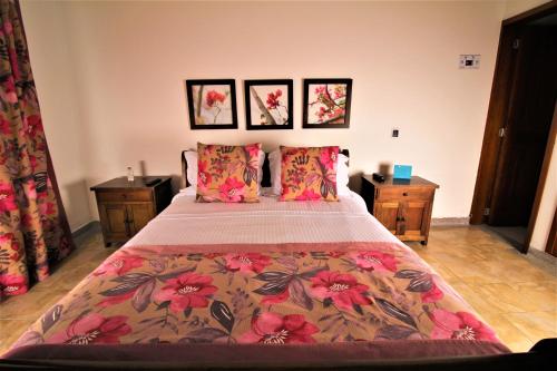 a bedroom with a large bed with flowers on it at Amazilia Hotel in Pereira