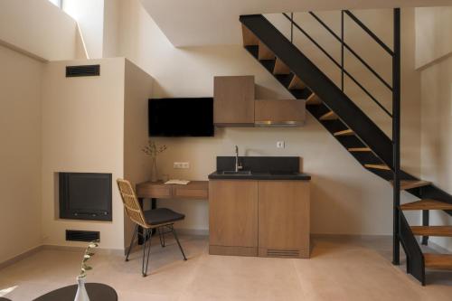 una cocina con escritorio y una escalera en Elivia Boutique Suites, en Almiropótamos
