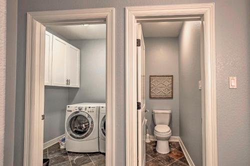 a bathroom with a washing machine and a toilet at Guadalupe River Paradise with Hot Tub, Dock and Kayaks in Seguin