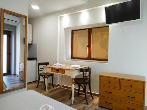 a room with a table and chairs and a kitchen at SUNNY DAYS in Limenaria