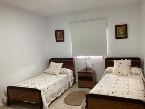 1 dormitorio con 2 camas y ventana en Cortijo rural La Parrilla, en Guadalcanal