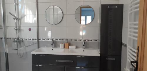 Saint-DidierにあるMaison d'Hôtes & Spa La Chêneraie-Provence Ventouxの洗面台と2つの鏡があるバスルーム