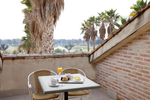 a table with a plate of food and drinks on a balcony at Ad Hoc Parque in Bétera