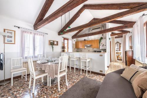 Il comprend un salon avec une table et une cuisine. dans l'établissement Colombina Like at home 3 bedrooms fully equipped air conditioned, à Venise