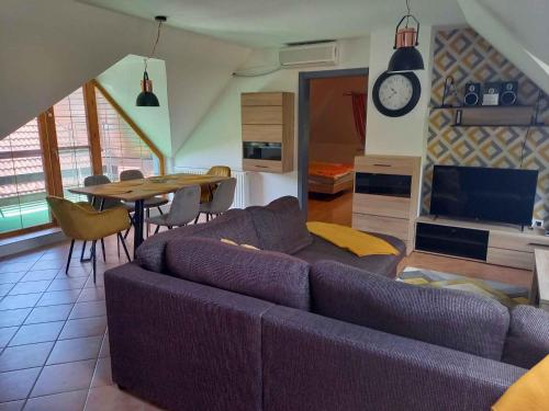 a living room with a purple couch and a table at Apartment in Balatonbereny - Balaton 26487 in Balatonberény