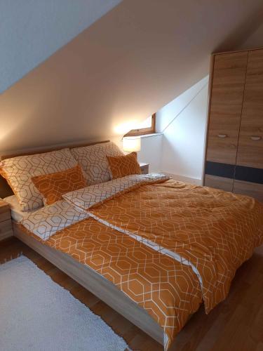 a bedroom with a bed with a orange comforter at Apartment in Balatonbereny - Balaton 26487 in Balatonberény