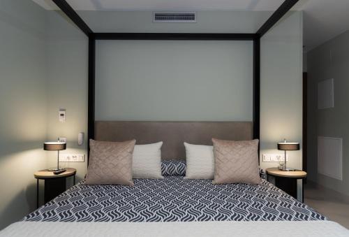 a bedroom with a bed with a large headboard at Hotel Perla del Sur in Torremolinos