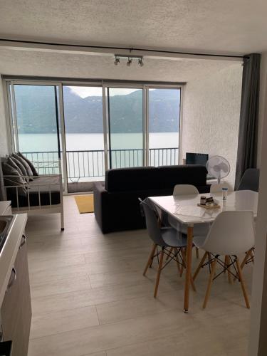 un salon avec un canapé et une table avec des chaises dans l'établissement Le Lamartine, vue magnifique face au Lac du Bourget, à Aix-les-Bains