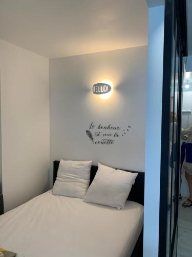 - un lit dans une chambre avec un panneau mural dans l'établissement Le Lamartine, vue magnifique face au Lac du Bourget, à Aix-les-Bains