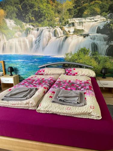 a bed with a painting of a waterfall at Ferienwohnung Fischach in Fischach