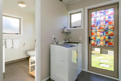 a bathroom with a sink and a toilet and a window at Mercy of Lake Taupo in Taupo