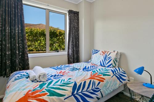 a bedroom with a bed with a view of a window at Mercy of Lake Taupo in Taupo