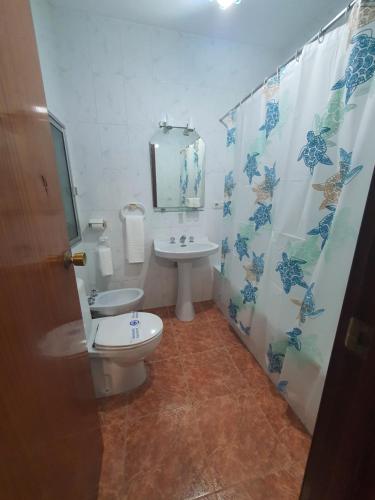 a bathroom with a toilet and a sink with a shower curtain at Los Príncipes in Palos de la Frontera