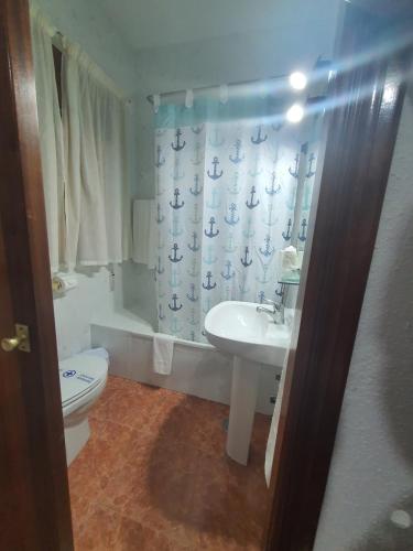 e bagno con lavandino, servizi igienici e tenda per la doccia. di Los Príncipes a Palos de la Frontera