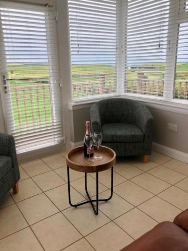 a living room with a bottle of wine on a table at Float bay view in Stranraer