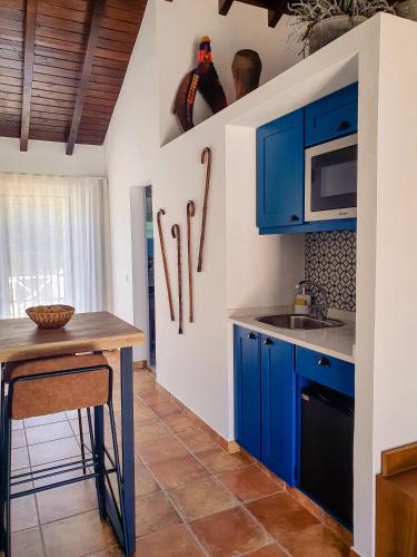a kitchen with blue cabinets and a wooden table at Monte do Brejinho de Água in Carvalhal