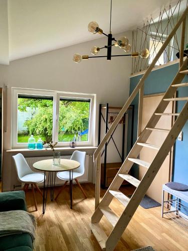 a living room with a staircase and a table at Galerie Apartment Self-Check-In in Kolbermoor