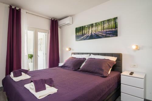Un dormitorio con una cama morada con toallas encima. en Arky, en Podstrana