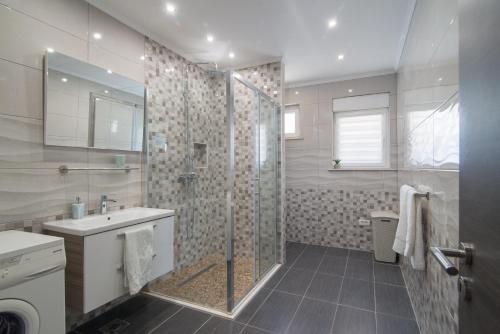 Un baño con ducha, lavabo e inodoro. en Arky, en Podstrana