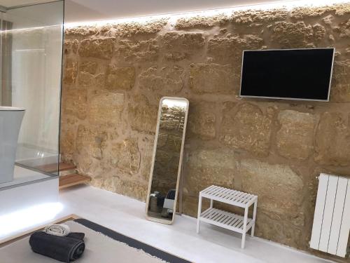 カステッランマーレ・デル・ゴルフォにあるLoft Incantevole Castellammare del Golfoの鏡とテレビ付きの壁のある部屋