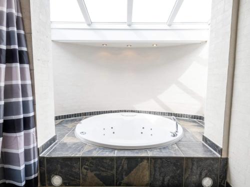 a bath tub in a room with a window at Luxury Panoramic Cottage in Rindby-By Traum in Fanø