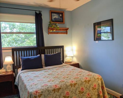 um quarto com uma cama, 2 candeeiros e uma janela em Fairhaven Guesthouse em Charlottesville