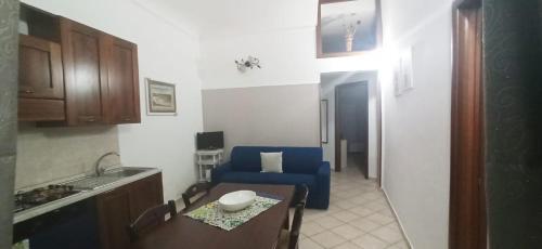 a kitchen with a blue chair and a table at Casa Orchidea in Siracusa