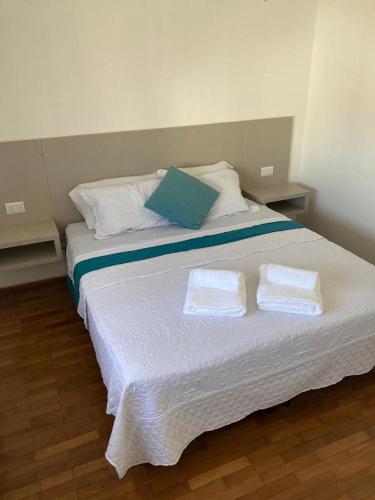 a large white bed with two towels on it at Apart Plaza in Río Cuarto