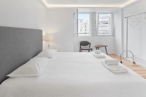 a white bedroom with a large white bed with white sheets at Room With Private Bathroom -Alcantara in Lisbon