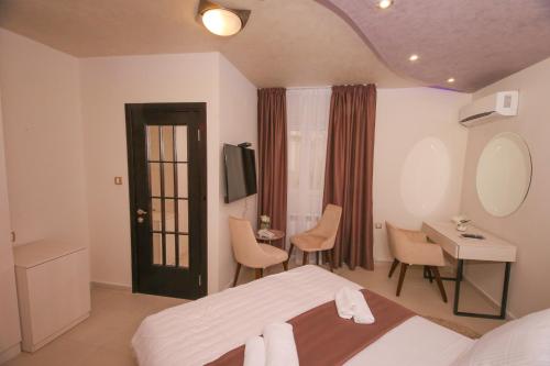 a bedroom with a bed and a desk and a mirror at Bajadera Lux in Belgrade