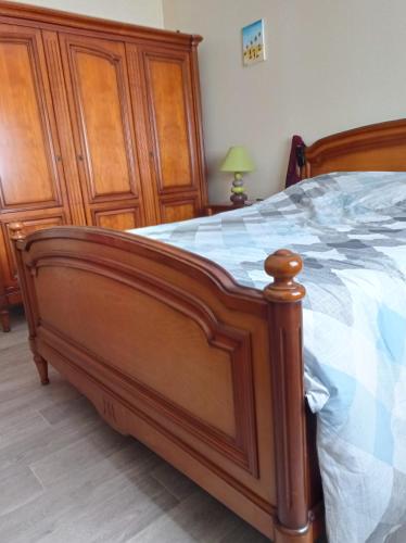 a wooden bed with a wooden frame in a bedroom at Chambre chez l'habitant in Saint Die