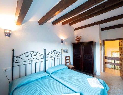 a bedroom with a blue bed in a room at Alojamientos Messía de Leiva in Segura de la Sierra