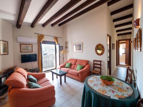 a living room with two couches and a table at Alojamientos Messía de Leiva in Segura de la Sierra