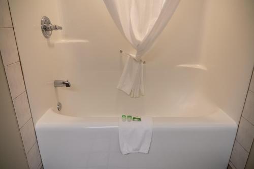 a white bath tub with a towel on it at Pocaterra Inn & Waterslide in Canmore