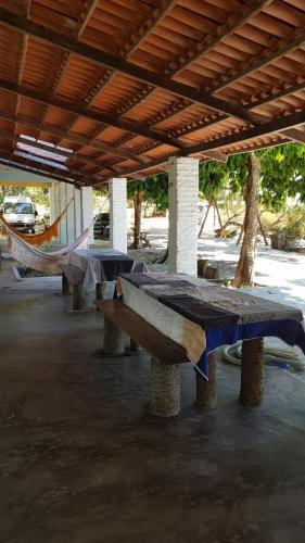 a group of picnic tables sitting under a roof at Rancho Colcha de Retalho in Caucaia