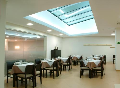 a dining room with tables and chairs and a skylight at Hotel Recinto in Fátima