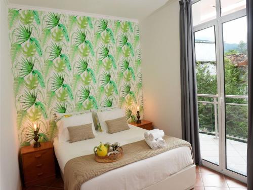 a bedroom with a bed with a tropical wallpaper at Flamingo Apartment in Furnas